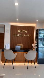 eine Hotellobby mit zwei Stühlen und einem Empfangstresen in der Unterkunft Keya hotel samui in Plai Laem