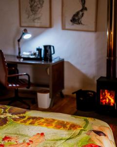 a room with a fireplace and a desk and a bed at Stanford Valley Country Lodge in Stanford