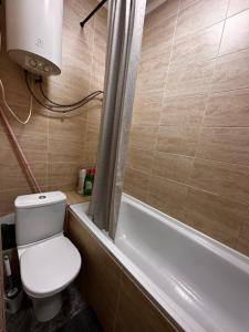 a bathroom with a toilet and a bath tub at 1 комн.квартира in Balqash