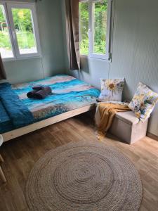 a bedroom with a bed and a couch and two windows at Purple Diamond in Damiş