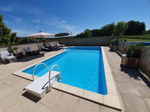 a swimming pool with a bench and an umbrella at Le Clos de La Réserve in Cinq-Mars-la-Pile +12 photos