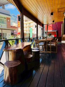 a patio with tables and benches on a wooden deck at 東光行旅 in Xinyi