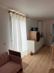 a living room with a couch and a kitchen at L'escale Cognaçaise in Cognac