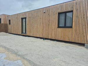 a wooden building with two windows on the side of it at L'escale Cognaçaise in Cognac
