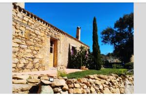 a stone building with a stone wall in front of it at holiday home su Niberalzu in Monti