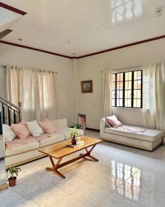 a living room with a couch and a coffee table at Casa Clara La Union in Dalumpinas Oeste