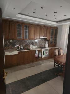 a kitchen with wooden cabinets and a table at Prenociste T-07 in Smederevo