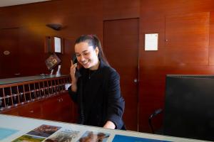 a woman talking on a cell phone in an office at Parc Hotel Casa Mia in Lazise +59 photos