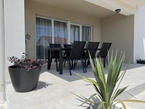 a patio with a black dining table and chairs at Apartment Terra Verde in Kastel Stari