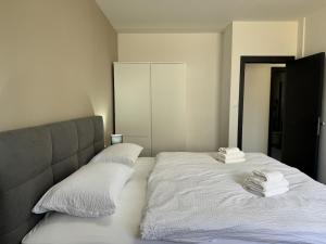 a bedroom with two beds with white sheets and towels at Apartment Terra Verde in Kastel Stari