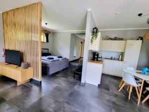a kitchen and a living room with a couch and a table at Heideberg Appartement in Zeuthen