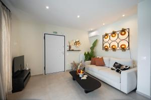 a living room with a white couch and a table at Kaerati Athens in Vari