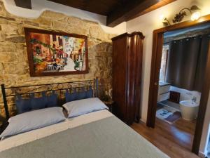 a bedroom with a bed and a stone wall at La Casa delle Rondini in Baunei