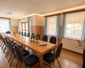 a conference room with a long wooden table and chairs at Chata Pod Hájkem in Vrchlabí +28 photos