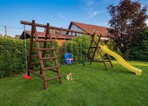 a playground with two swings and a slide at Chata Pod Hájkem in Vrchlabí