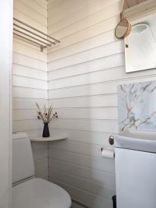 a white bathroom with a toilet and a sink at Villa Väderkulla in Porvoo +45 photos
