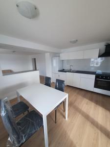 a kitchen with a white table and chairs in a room at Janez house in Metlika