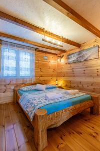 a bedroom with a bed in a log cabin at Bamboo River House in Ulcinj