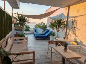 a patio with tables and chairs and potted plants at Hotel George suite 2 in Limenas