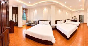 two beds in a large room with wood floors at Khách Sạn Mỹ Kim in Cà Mau +48 photos