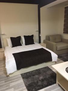 una camera con un grande letto e un divano di Hotel Restoran EPI a Valandovo