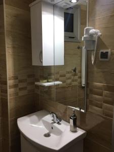 bagno con lavandino bianco e specchio di Hotel Restoran EPI a Valandovo