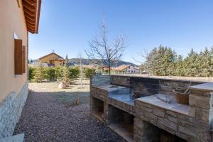 a stone fire pit in a yard next to a house at Casa Las Tinajas in Alcalá de la Selva
