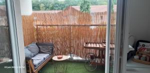 a small balcony with a couch and a fence at Suite-Appart Beau Soleil - 24H Le Mans Métropole in Allonnes
