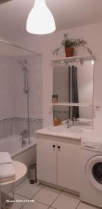 a bathroom with a sink and a tub and a toilet at Suite-Appart Beau Soleil - 24H Le Mans Métropole in Allonnes +12 photos
