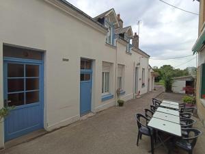 a row of tables and chairs in front of a building at Le bouf tard chambre vue sur jardin CH7 in Vendôme