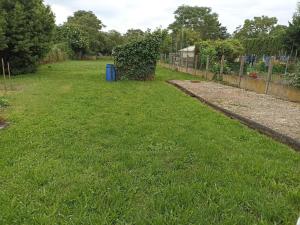 a yard with green grass and a fence at Le bouf tard chambre vue sur jardin CH7 in Vendôme