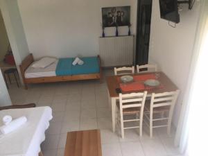 a small room with a bed and a table and chairs at Panorama Apartment 1 in Moúdhros