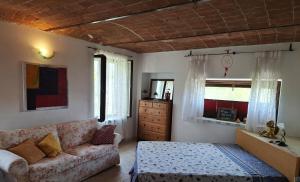 a living room with a couch and a bed at Cascina E&E in Costigliole dʼAsti
