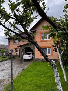 a house with a car parked in front of it at Котедж "Під Крилом" in Dilyatyn