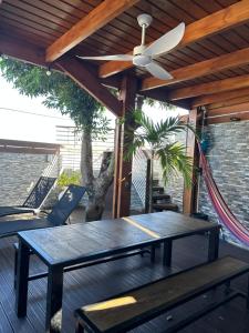 a patio with a table and a ceiling fan at L'Orchidée in Les Avirons