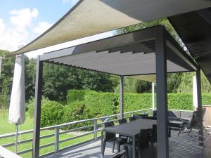 a pavilion with a table and chairs on a deck at La Semois Et Moi in Rochehaut