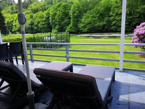 a porch with two chairs and an umbrella at La Semois Et Moi in Rochehaut