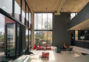 a lobby with large windows and people sitting at Mevan Hotel Dalat in Da Lat