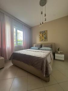 a bedroom with a large bed and a large window at Blue Paradise - Gjiri i Lalezit in Lalzit Bay