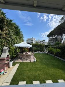 a garden with chairs and an umbrella and grass at Blue Paradise - Gjiri i Lalezit in Lalzit Bay +33 photos