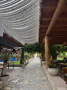 a patio with a row of tables and chairs and a building at Blue Paradise - Gjiri i Lalezit in Lalzit Bay