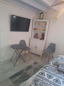 a bedroom with a tv and a table and chairs at Calme et quiétude in Saint-Vivien-de-Blaye