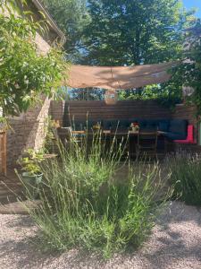 a garden with a couch under a canopy at La Rotonde in Poligny +20 photos