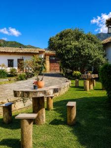 a picnic table and benches in a yard at Hotel Pueblo Dorado Sesquilé in Sesquilé