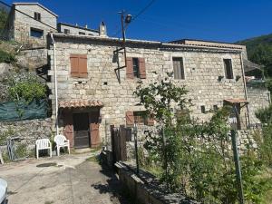 an old stone house with a fence in front of it at Studio refait à neuf Chez Linda in Zicavo +9 photos