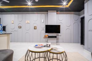 a living room with a tv and a table at Modern executive stay in Lahore Long stay ready in Lahore