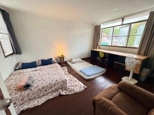 a bedroom with a bed and a couch and windows at Southeast Asia Activist House in Bangkok