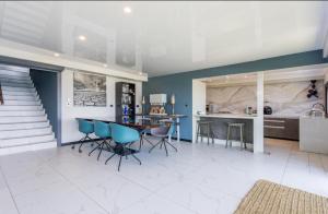 a kitchen and dining room with blue walls and a table and chairs at Flamenco@Colwyn in Sheffield Beach +19 photos