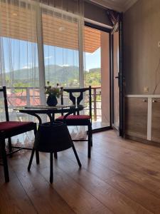 a dining room with a table and chairs and a balcony at Sunny Days Borjomi in Borjomi +50 photos
