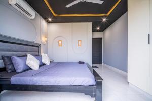 a bedroom with a large bed with purple pillows at Modern executive stay in Lahore Long stay ready in Lahore +7 photos